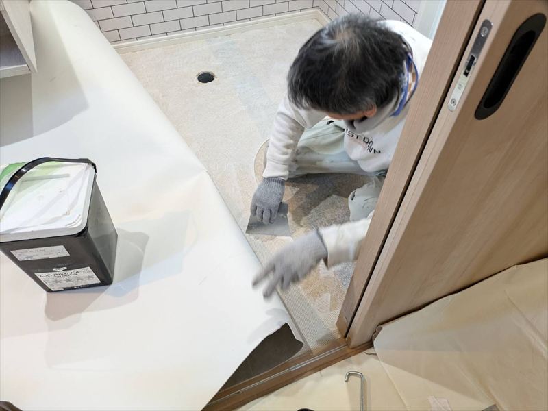 接着剤を床に広げる職人