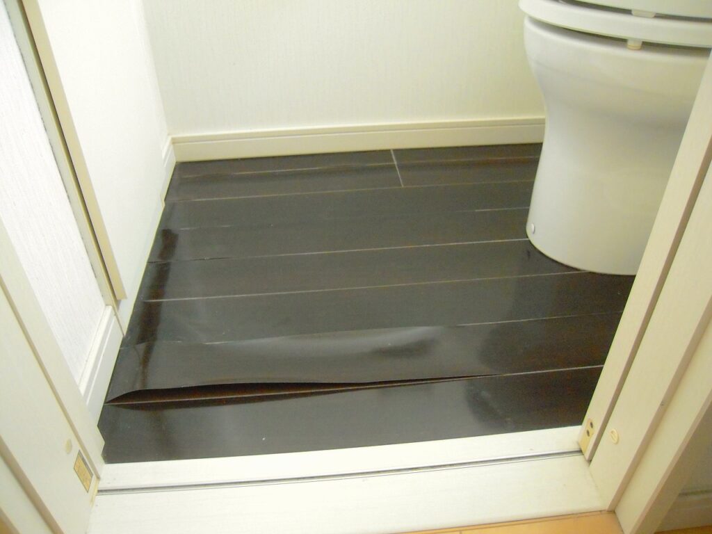 強化フィルムが剥がれたトイレの床