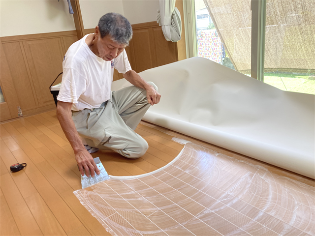 くしベラで接着剤を広げる職人