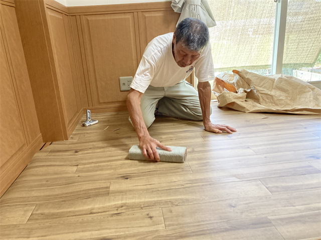 クッションフロアの敷設仕上げをする職人