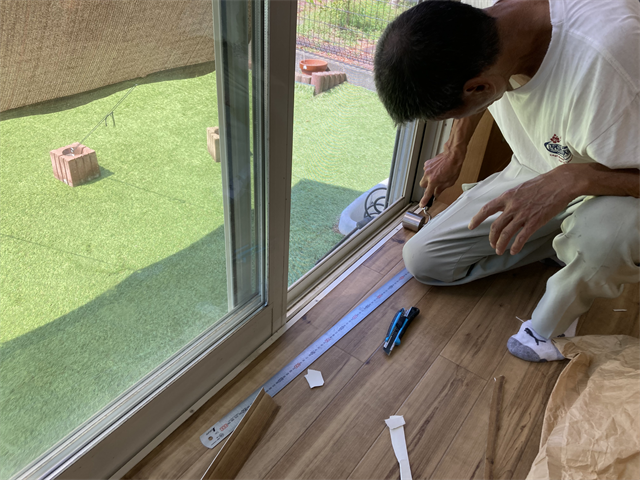 ローラーでクッションフロアを圧着させる職人