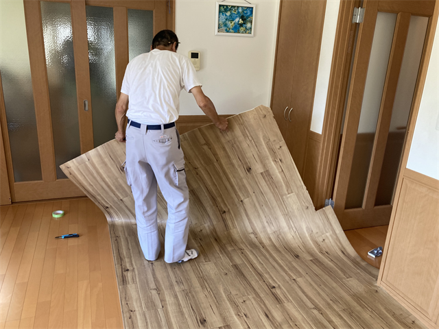 床にクッションフロアを被せる職人