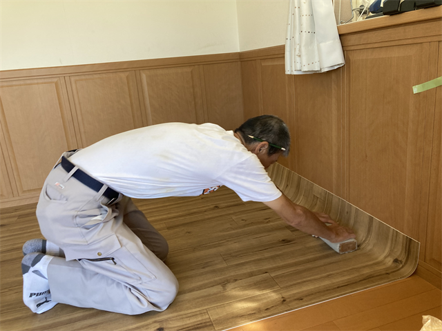 壁際の新設した床材をなじませる職人