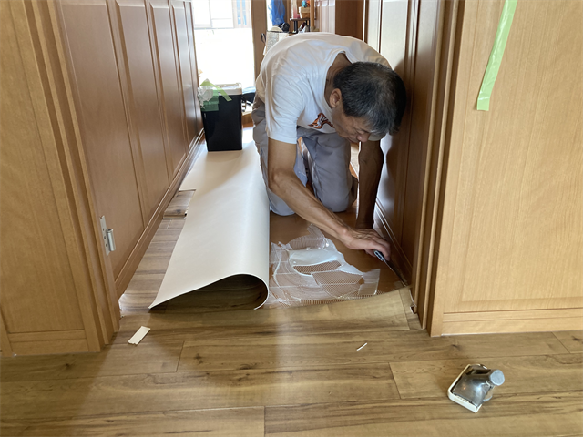 廊下部分に接着剤を塗り広げる職人