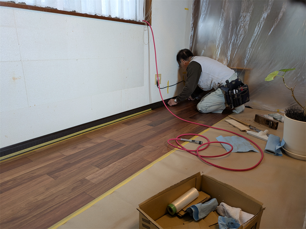 壁際にマスキングテープを貼る職人